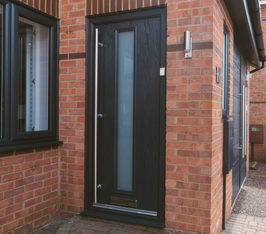 Black door with glass centre panel on red brick house