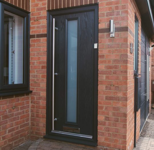 Black door with glass centre panel on red brick house