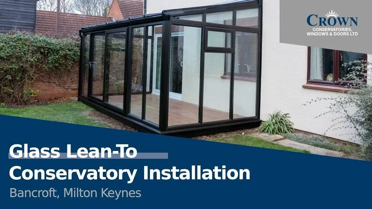 A modern glass lean-to conservatory with a black aluminium frame, installed at a home in Bancroft, Milton Keynes, providing extra living space.
