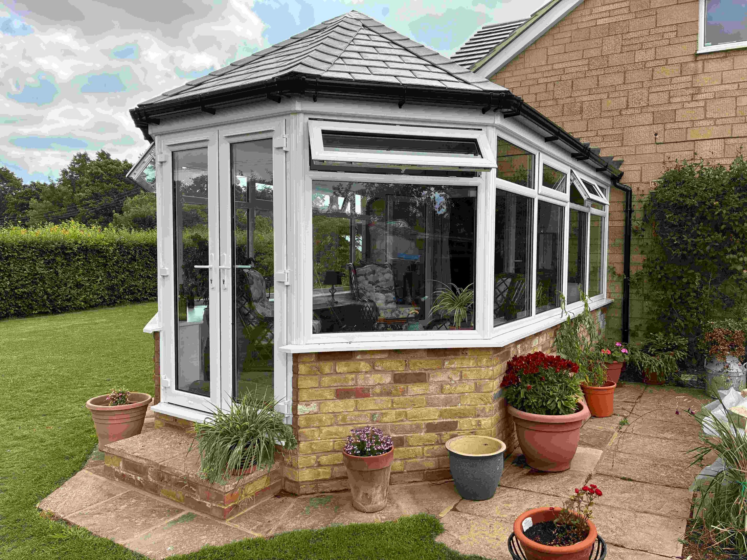 The Crown team installing a Victorian conservatory in Northamptonshire. The conservatory is in the Victorian style, and has been completed with a Guardian warm roof for added insulation. There is a large garden, with the roof promising year-round comfort.